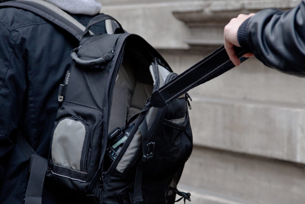 aschendieb öffnet unbemerkt einen Rucksack in der Öffentlichkeit